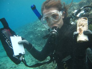 Steph Duce showing a coral core underwater in Tahiti